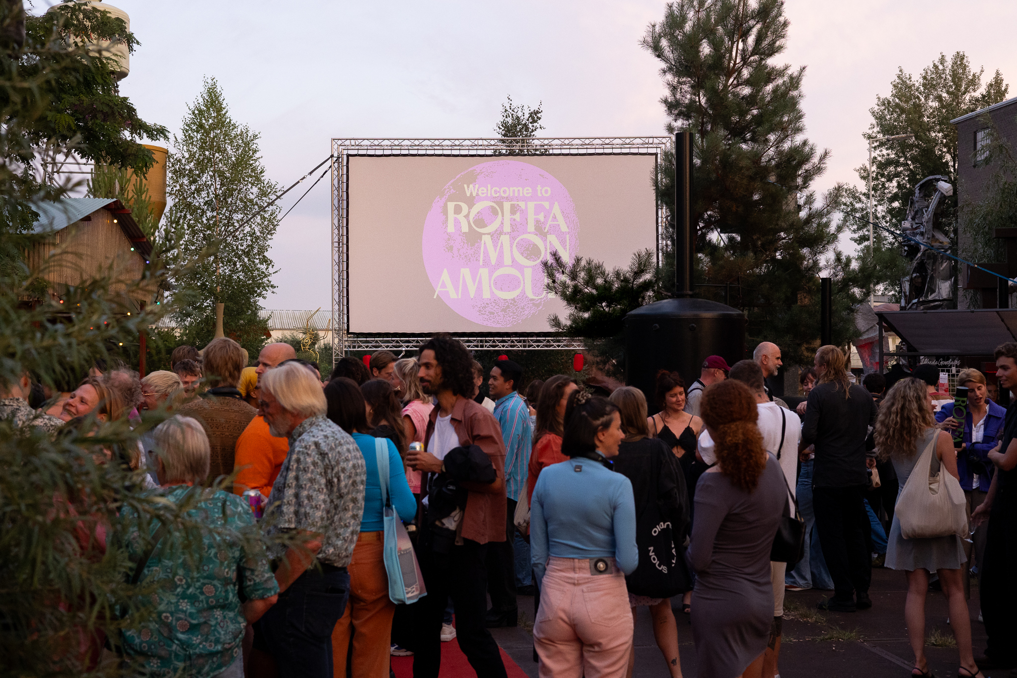 Er staan mensen buiten en achter zie je een bioscoopscherm met de tekst Roffa Mon Amour