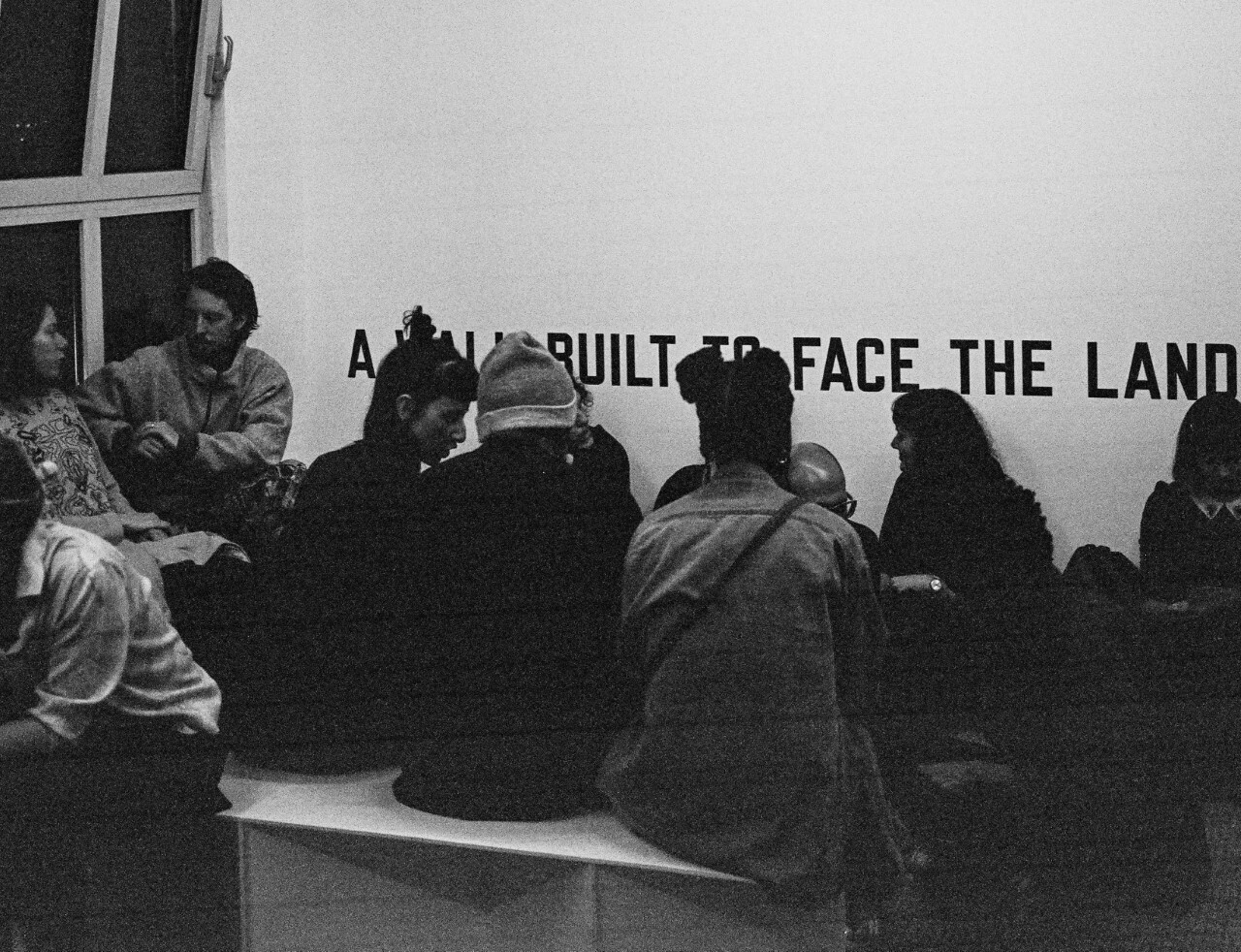 Groep mensen - alleen ruggen zichtbaar - tijdens expositie bij Shimmer