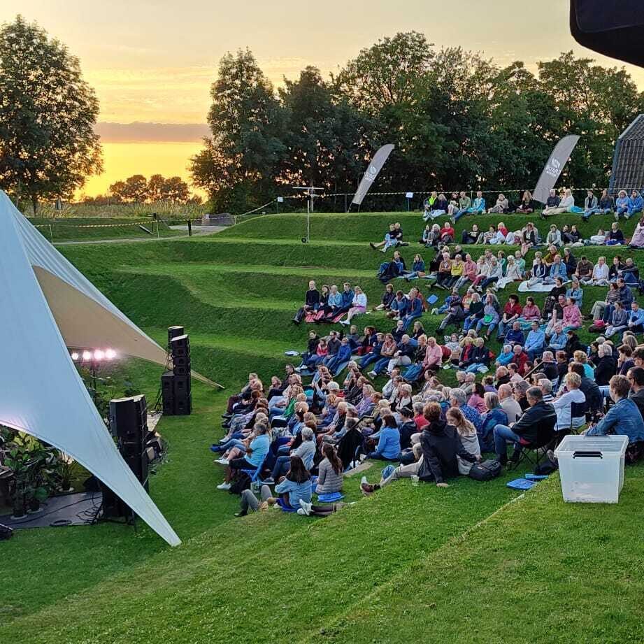 Een tent in een met gras bekleed buiten theater
